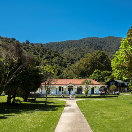 Large sweeping lawns and the front of historic Howden House with its distinctive verandah and orange tiled roof, in the Marlborough Sounds at the top of New Zealand's South Island.