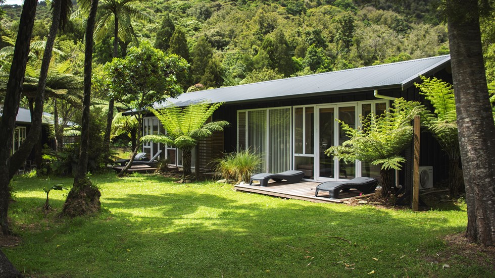 An Endeavour Suite is surrounded by native bush and lush greenery at Furneaux Lodge in the Marlborough Sounds, New Zealand.
