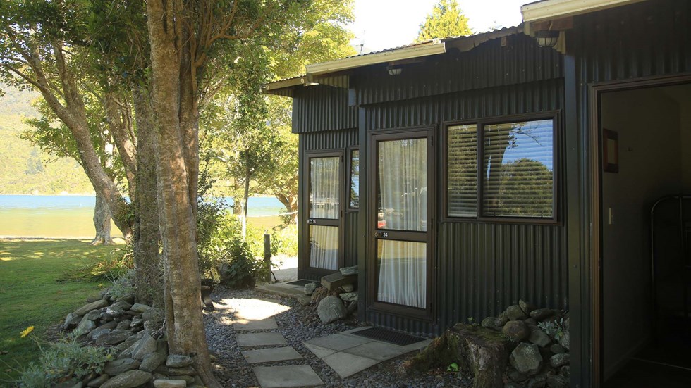 Three Hiker's Cabins surrounded by trees at Furneaux Lodge in the Marlborough Sounds at the top of New Zealand's South Island.