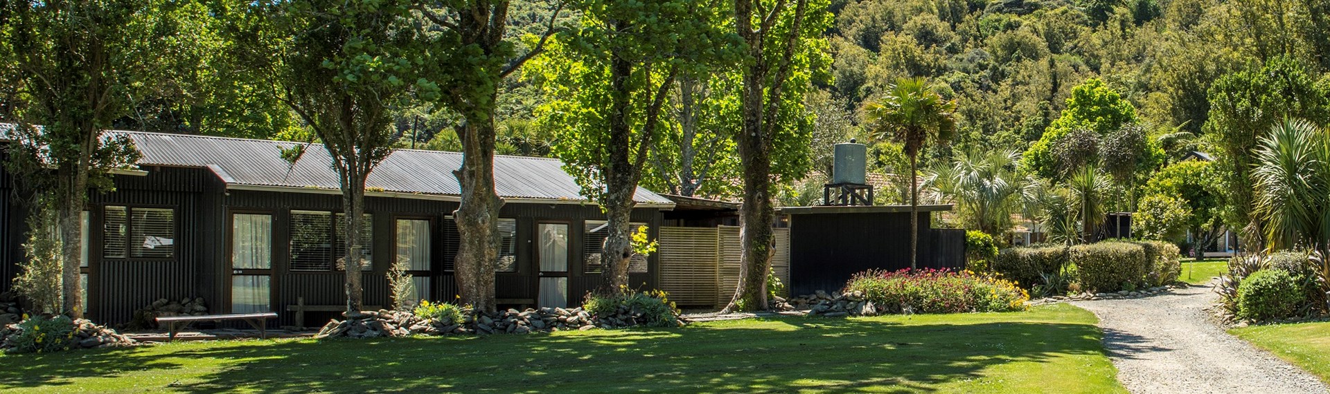 Hiker's Cabins surrounded by tall trees at Furneaux Lodge in the Marlborough Sounds, New Zealand.