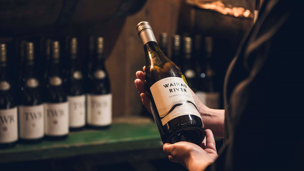 A bottle of Wairau River Sauvignon Blanc is chosen from the Restaurant and Bar wine cellar at Furneaux Lodge in the Marlborough Sounds, New Zealand.