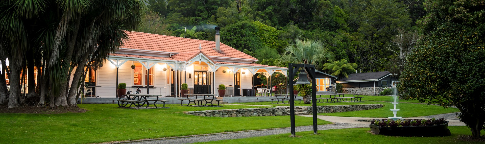 The front of historic Howden House with orange tiled roof and lawn in front, in the Marlborough Sounds at the top of New Zealand's South Island.